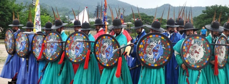 Turquoise hanbok wearing men wielding shields at the changing of the guard, Gyeongbokgung Palace, Seoul