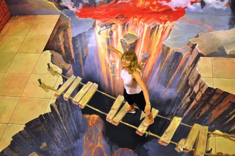 Sue crossing a precipice streaming red hot lava at the Alive Museum, Jeju, South Korea